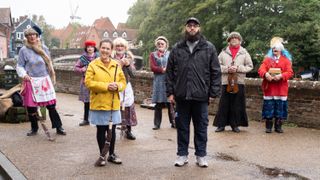 Rosie Jones and Jamali Maddix with folk dancers in traditional costume in Norwich