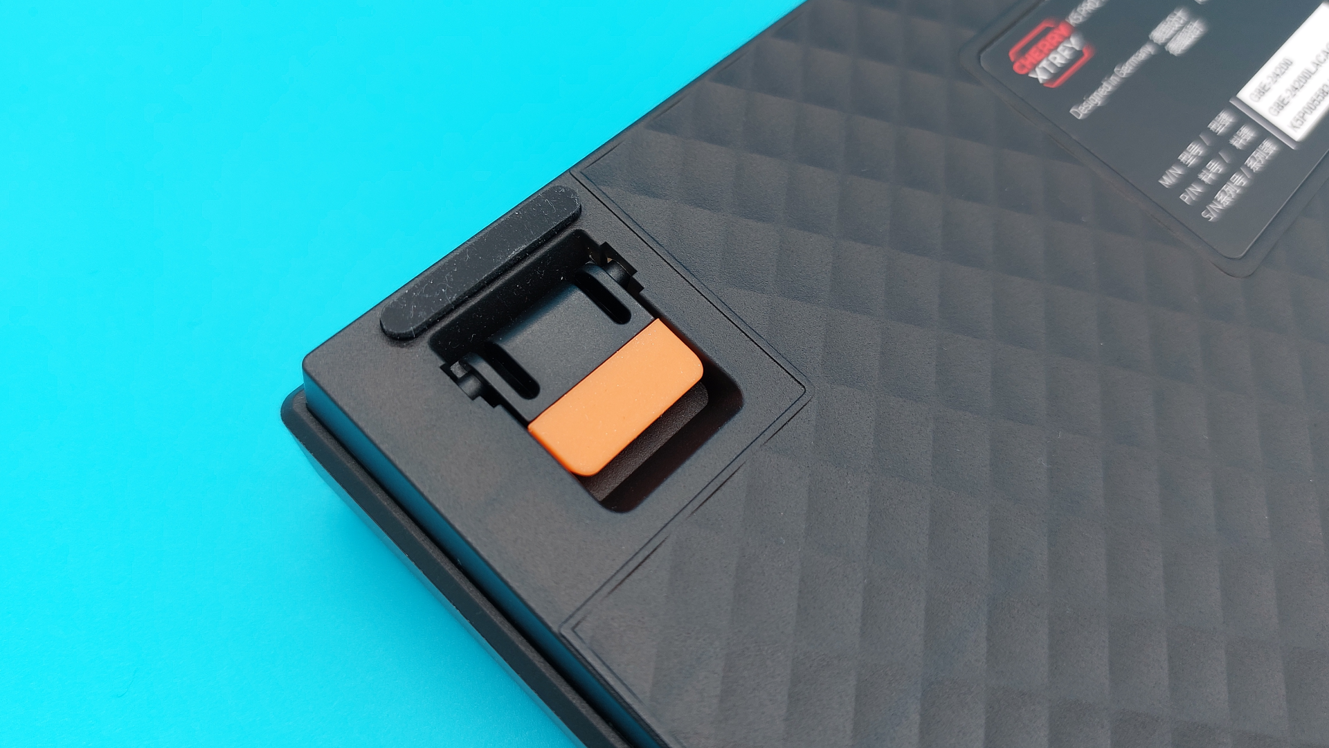 The Cherry K5 Pro TMR Compact seen from the back, focussing on the orange feet that can be flipped out to prop up the gaming keyboard.