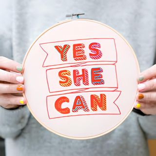 A completed sewing kit with embroidered text Yes She Can