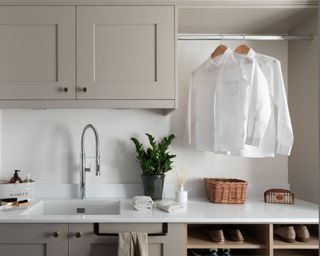 Laundry room with sink and hanging rail for freshly ironed garments