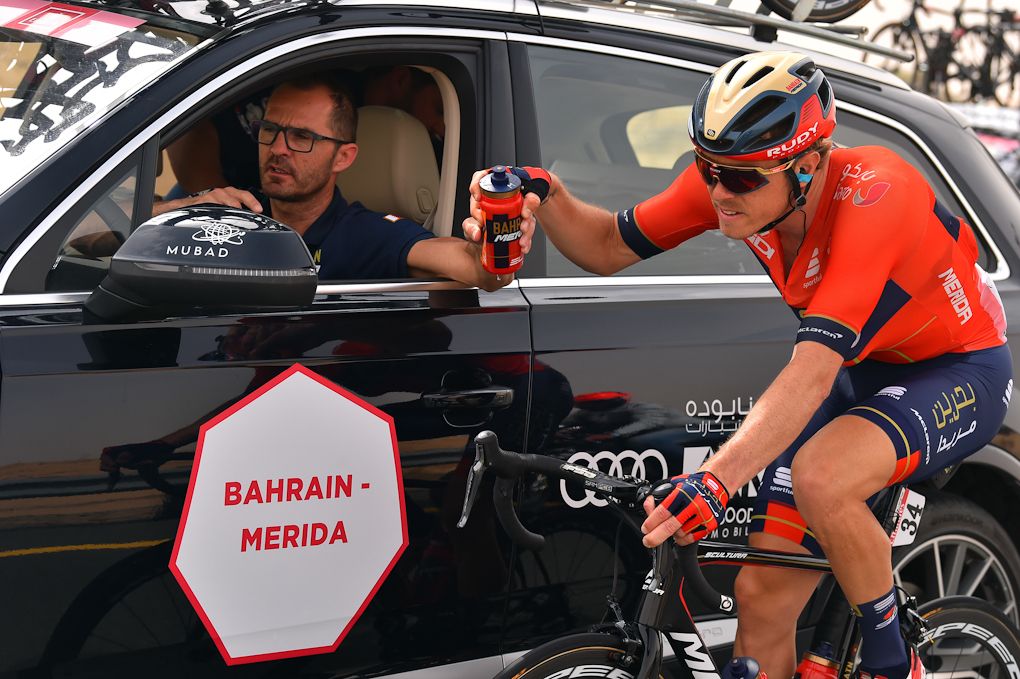 Bahrain-Merida's Gorazd Stangelj hands a bottle to Rohan Dennis at the 2019 UAE Tour