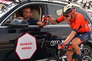 Bahrain-Merida's Gorazd Stangelj hands a bottle to Rohan Dennis at the 2019 UAE Tour