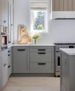 modern kitchen with gray cabinets, black handles and white walls