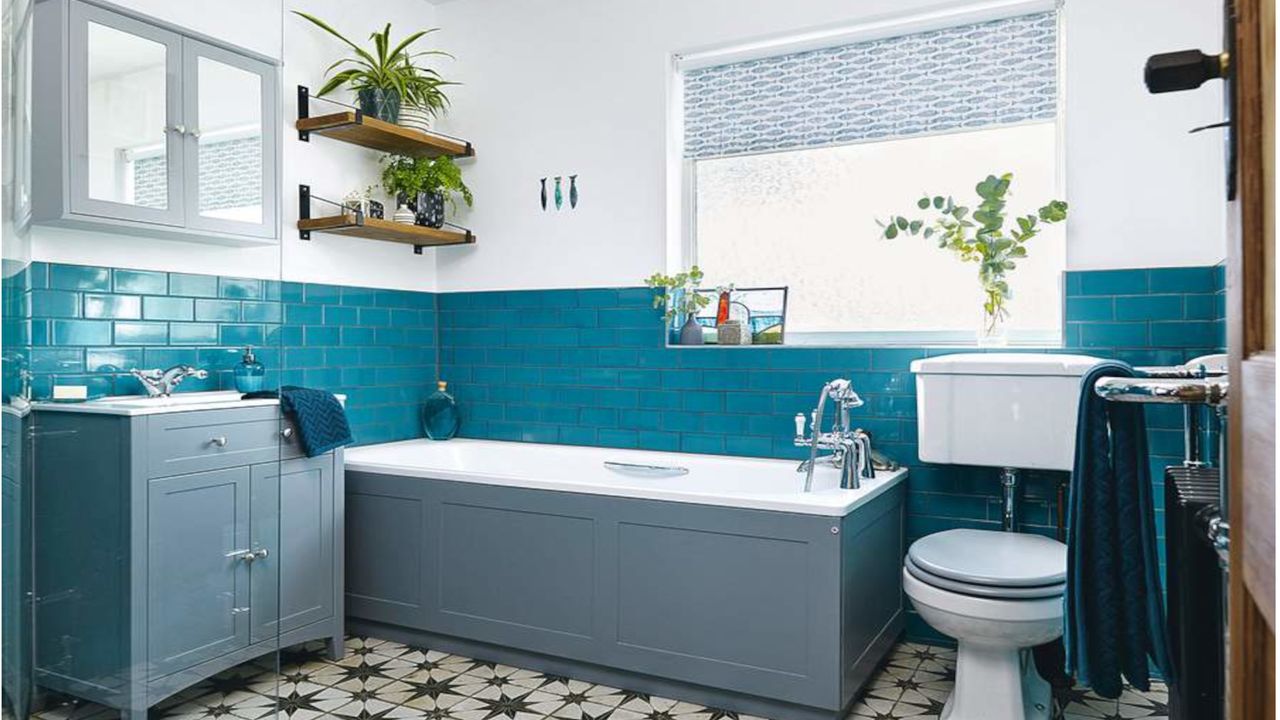 Bathroom with grey bath panels and sink cabinetry alongside turquoise metro wall tiles