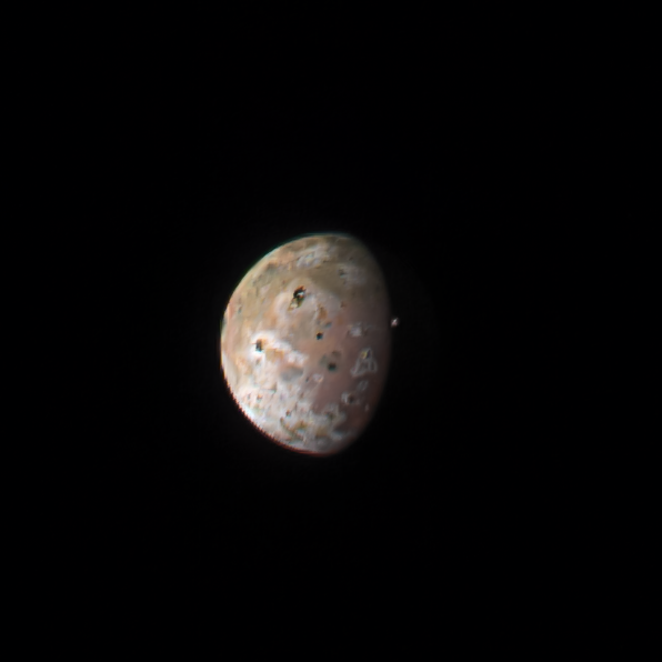 a gray and orange moon pockmarked with craters