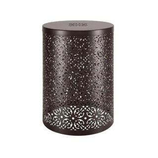 A cylindrical metal patio table with a cut-out pattern