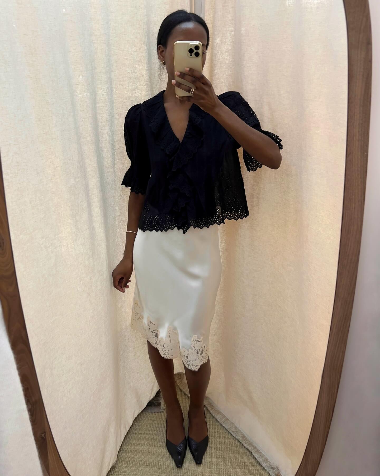 Stylie Mus wearing cream silk skirt with lace and black top