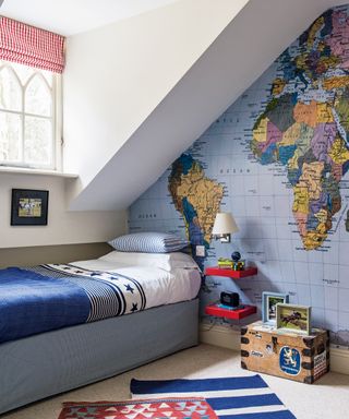 Bedroom ideas for boys featuring a blue, white and red color scheme with statement map of the world wall.