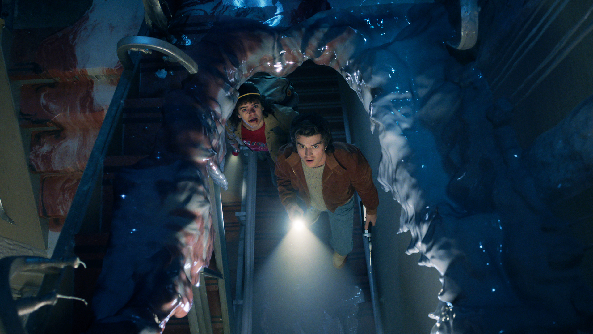 Dustin and Steve looking up through a torn-through truck in Stranger Things season 5