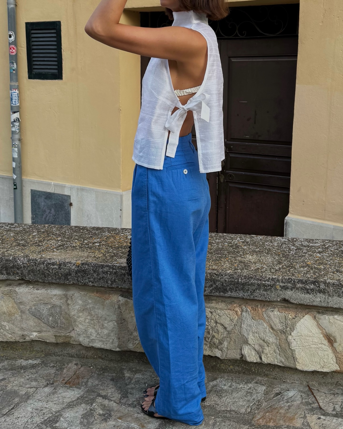 An image of @smythsisters wearing a white apron top with cobalt trousers.