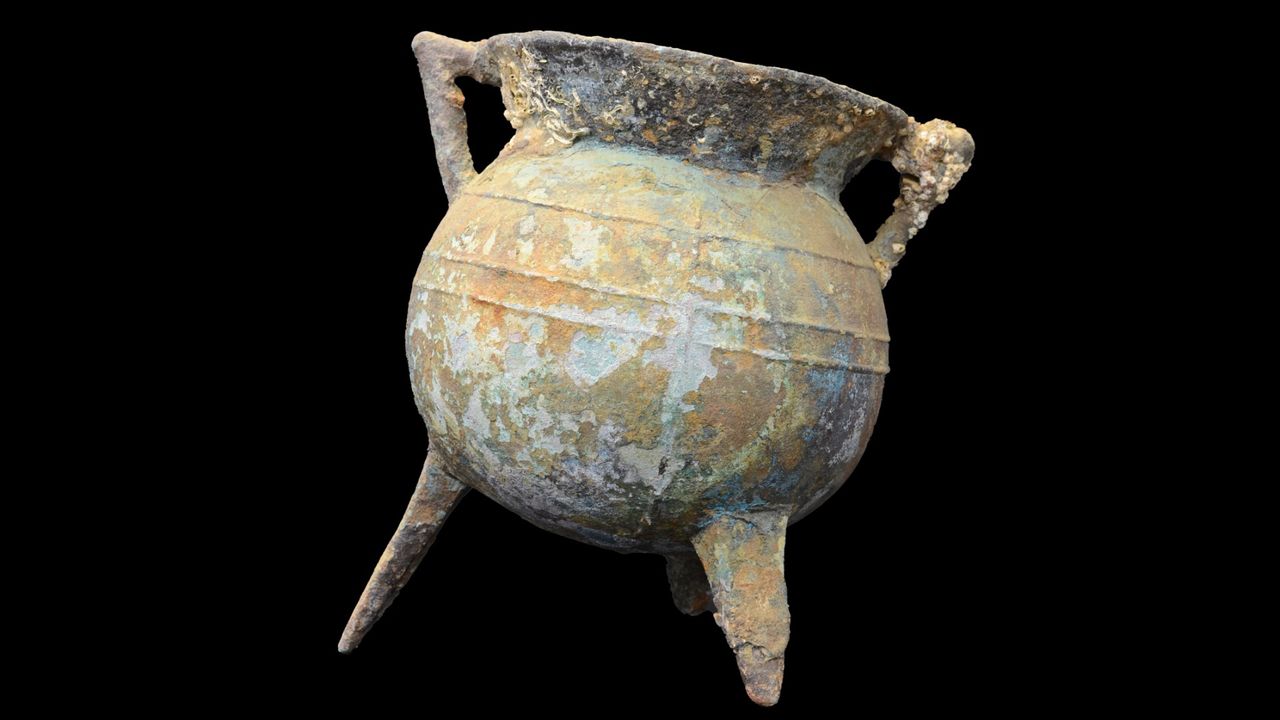 A large stone cauldron that looks very worn as it has been lost in the ocean for a long time.