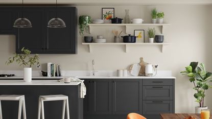 A kitchen with black cabinets and walls painted in Egyptian Cotton by Dulux