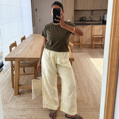 monikh wears a green tee, drawstring pants, and green flip-flops.