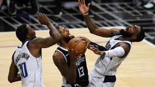 Paul George #13 of the LA Clippers reacts as he is called for an offensive foul as he drives to the basket between Dorian Finney-Smith #10 and Tim Hardaway Jr. #11 of the Dallas Mavericks during the fourth quarter in a 113-103 Mavericks win during game one of the Western Conference first round series at Staples Center on May 22, 2021 in Los Angeles, California.