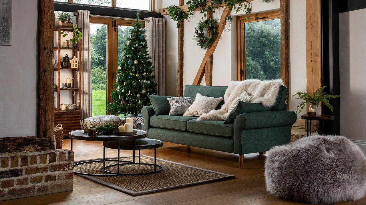 A rustic living room with green upholstered sofa and wooden beams