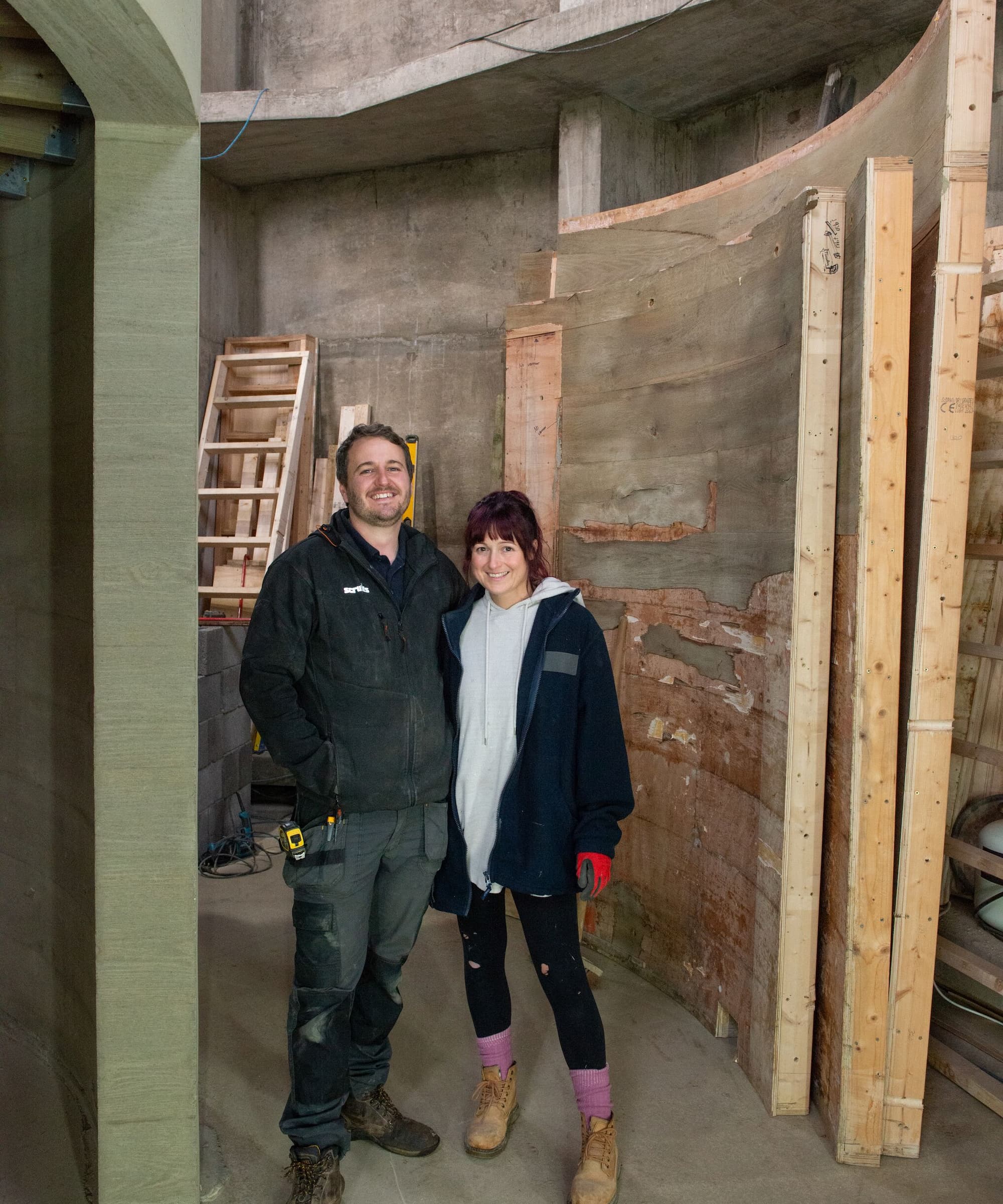 A couple standing in a concrete wall structure on a first floor