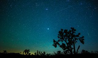 meteors streak through the starry night sky, leaving trails of light