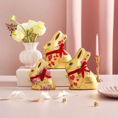 Lindt easter bunnies on pink background with flowers