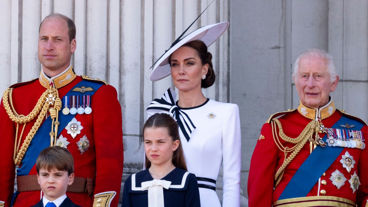 Kate Middleton wears a white dress with navy piping as she stands on the balcony with Prince William and King Charles, who wear military uniform