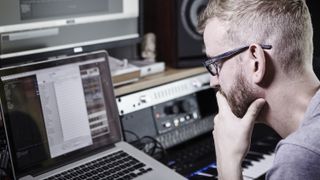 Man focuses on his laptop during a recording session