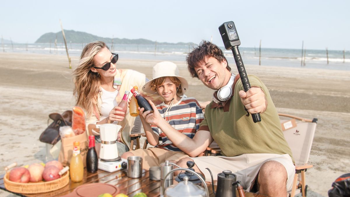 Vantrue E360 dash cam attached to selfie grip with family at the beach shooting a video