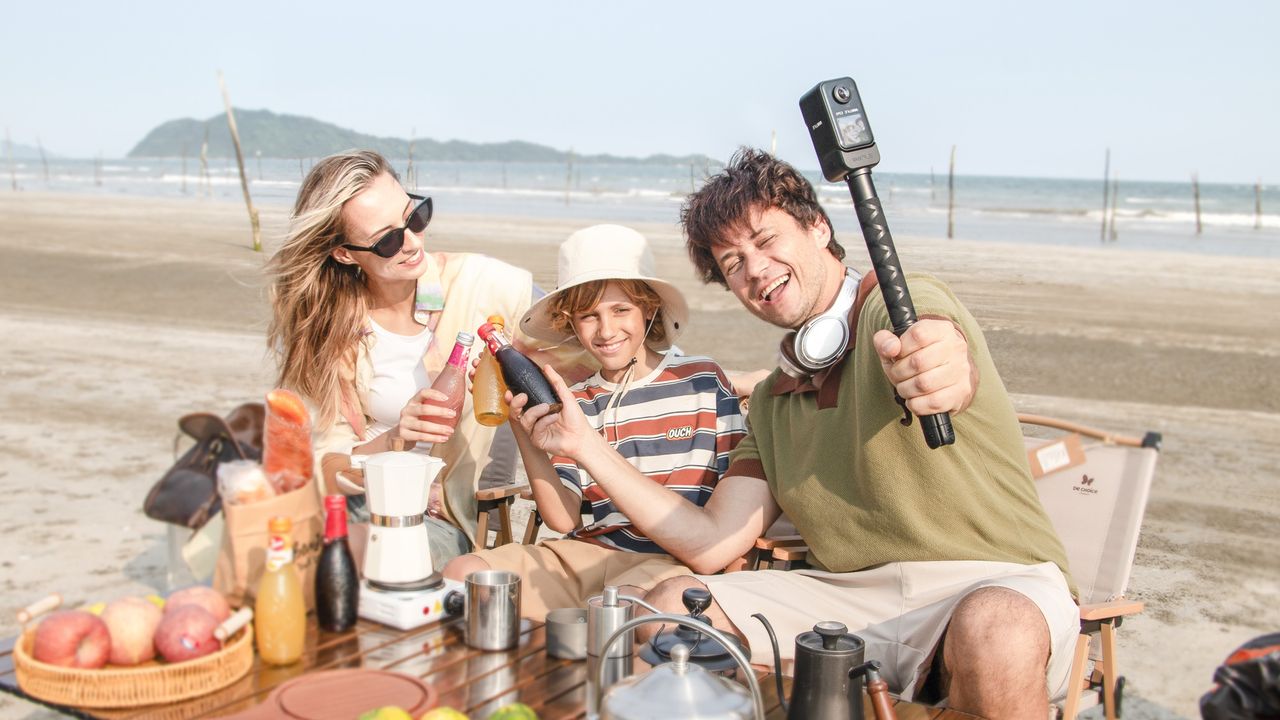 Vantrue E360 dash cam attached to selfie grip with family at the beach shooting a video