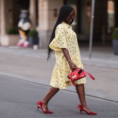 Fashion Week attendee wears yellow dress and red shoes