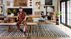 Bobby Berk and his dog sitting in a black, white and brown dining room