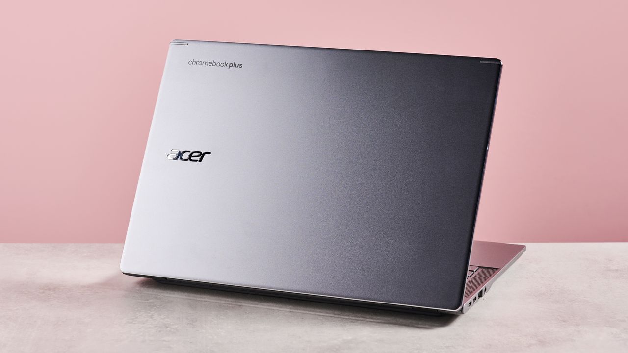 Back of Acer Chromebook Plus 516 open on desk with pink background