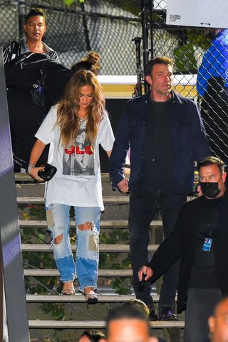 Jennifer Lopez and Ben Affleck hold hands as they walk down a flight of stairs