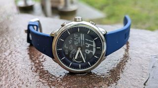 The Fossil Gen 6 Hybrid Wellness Edition on a wet surface