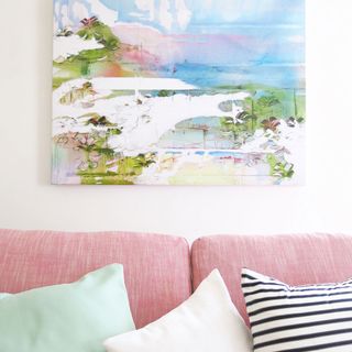 living room with wall painting and pink sofa