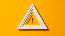 A triangle outlined in white with an exclamation point in the center against a yellow background.