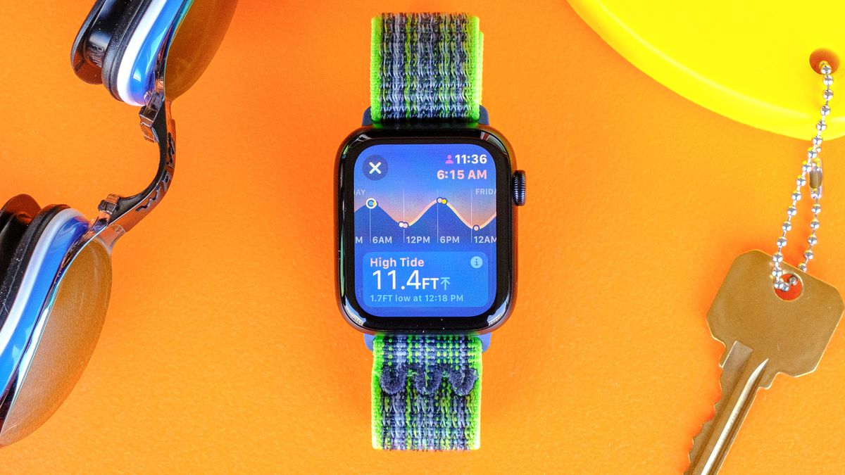 Apple Watch SE 2022 on an orange table with the new Tides app screen displayed