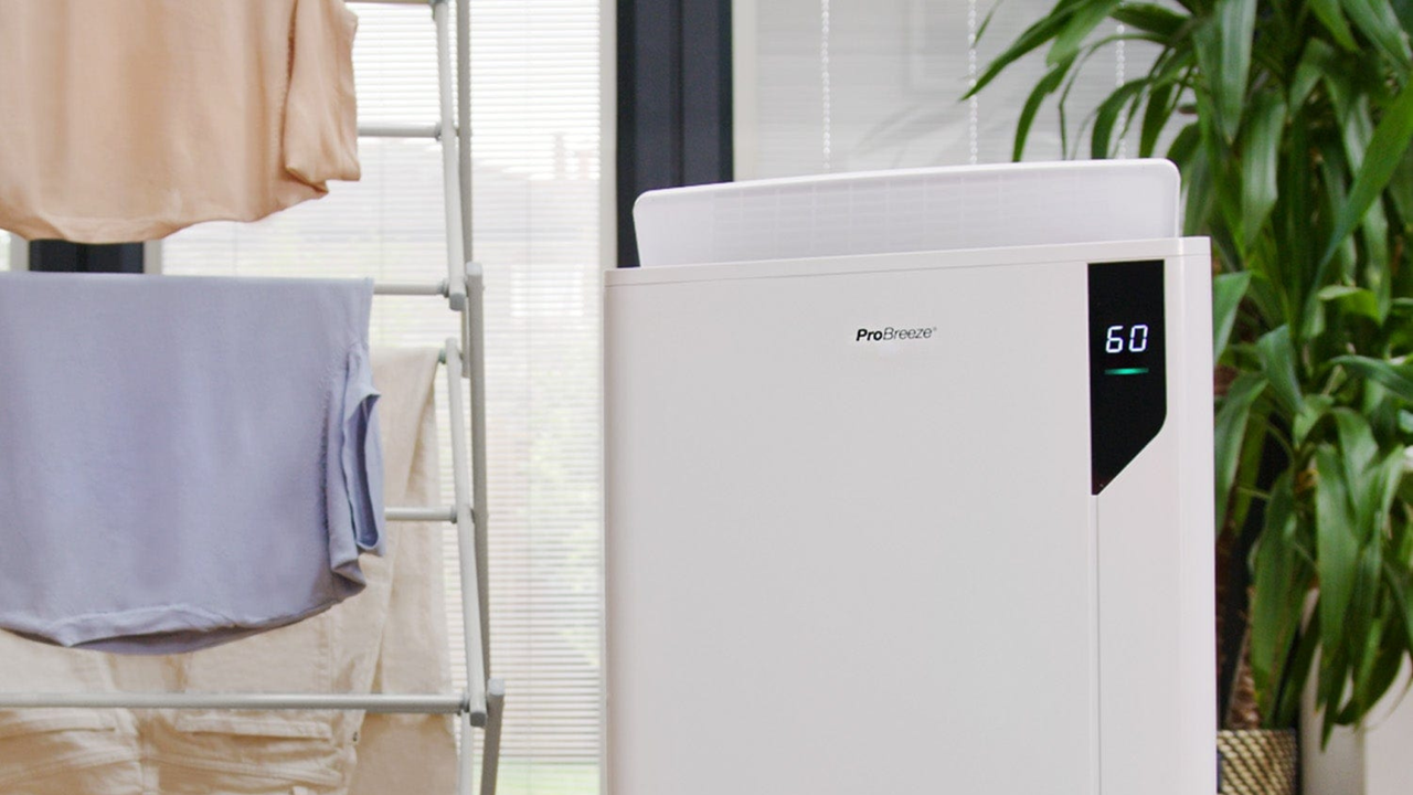 Pro Breeze dehumidifier beside laundry drying on airing rack