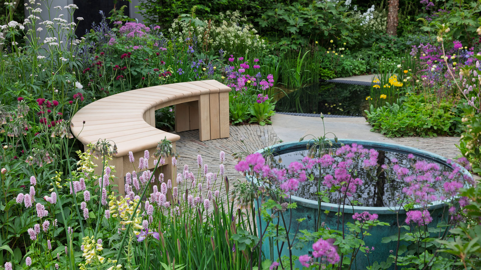 flower garden with bench and water feature