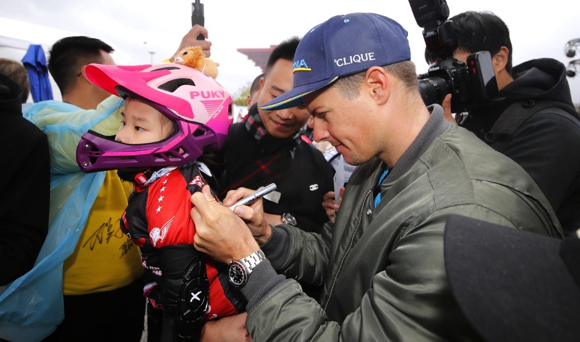 Jakob Fuglsang autographs a child