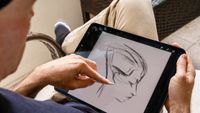 Procreate custom brush tips from Kyle T Webster; a man draws on a iPad