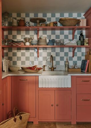 A kitchen with a tiled backsplash and shelving