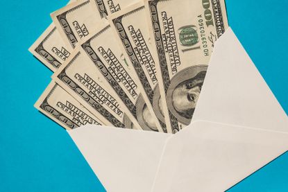$100 bills in an envelope on a blue background