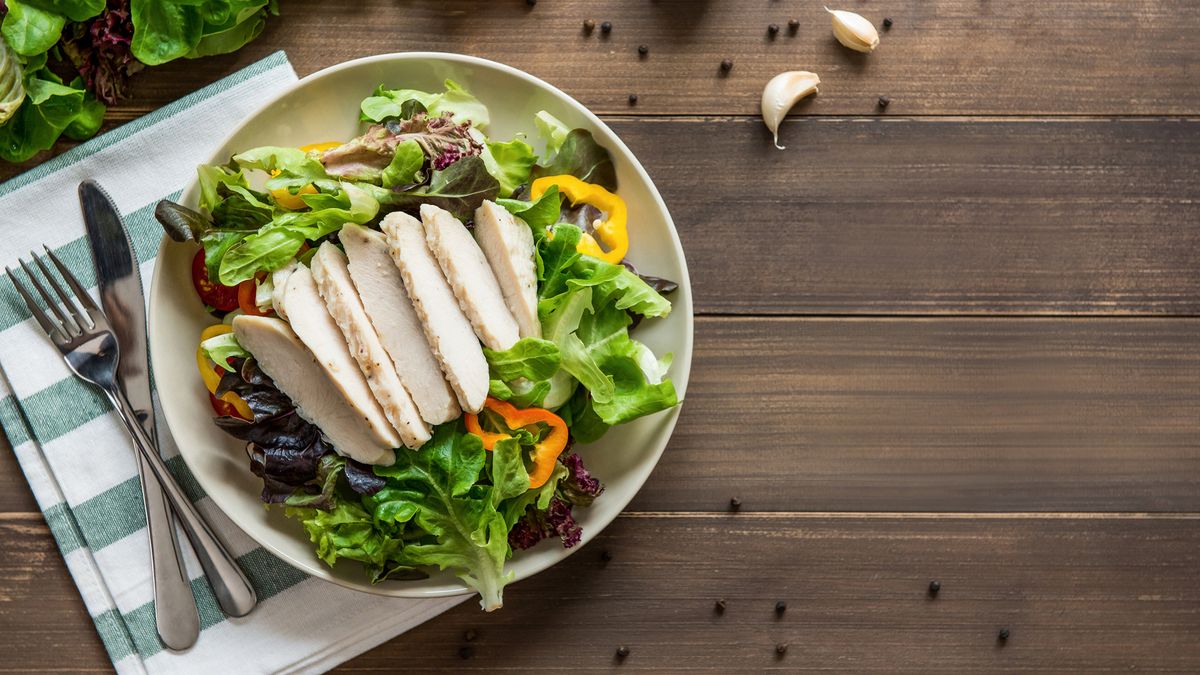 plate of lean chicken breast on a bed of salad