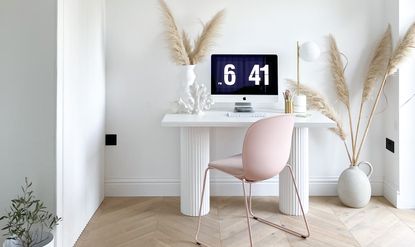 home office with a DIY desk with fluted legs and a pink desk chair and pampas grass
