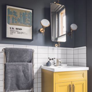 Bathroom with yellow cabinet and art print on wall.