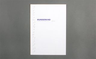 View of ﻿Wunderkind's white stapled invitation pictured against a grey background
