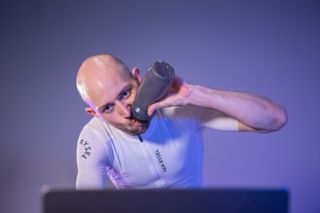 A close up shot of a rider drinking during an indoor workout