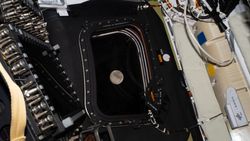 A view of the moon through a window of a space capsule.