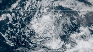 a white swirling cloud over the dark blue of the ocean, as seen from a satellite in space