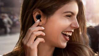 A woman laughing as she listens to music with the Samsung Galaxy Buds