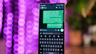 WhatsApp chat displayed on a Samsung Galaxy S24 Ultra screen with purple lights blurred in the background