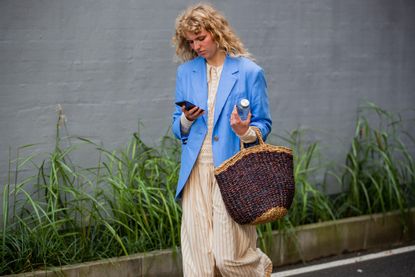 Fashion week attendee carrying one of the best beach bags, Prada's crochet tote. 